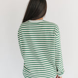 Person wearing a green and white striped shirt on a plain background