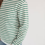 Woman wearing an oversized fit freestyle stripe breastfeeding sweatshirt in green and white.