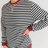 Woman wearing a striped long-sleeve shirt with red trim on a white background