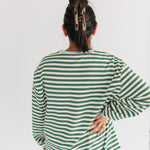 Person wearing a green and white striped shirt on a plain background