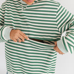 Person wearing a green and white striped sweater on a plain background