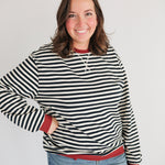 Woman wearing an oversized fit freestyle stripe breastfeeding sweatshirt with a smile.