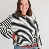 Woman wearing an oversized fit freestyle stripe breastfeeding sweatshirt with a smile.