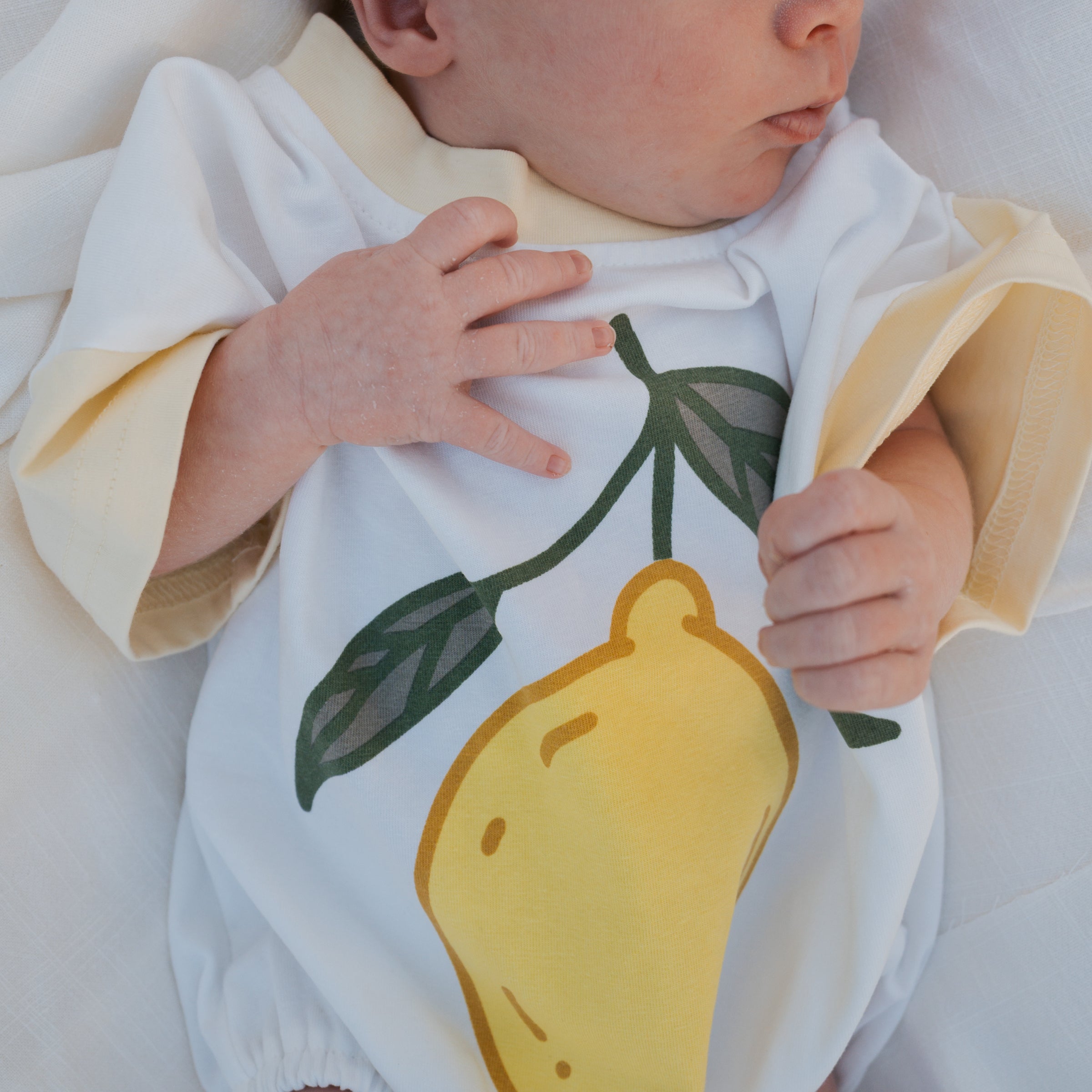 Baby wearing a onesie with a lemon design
