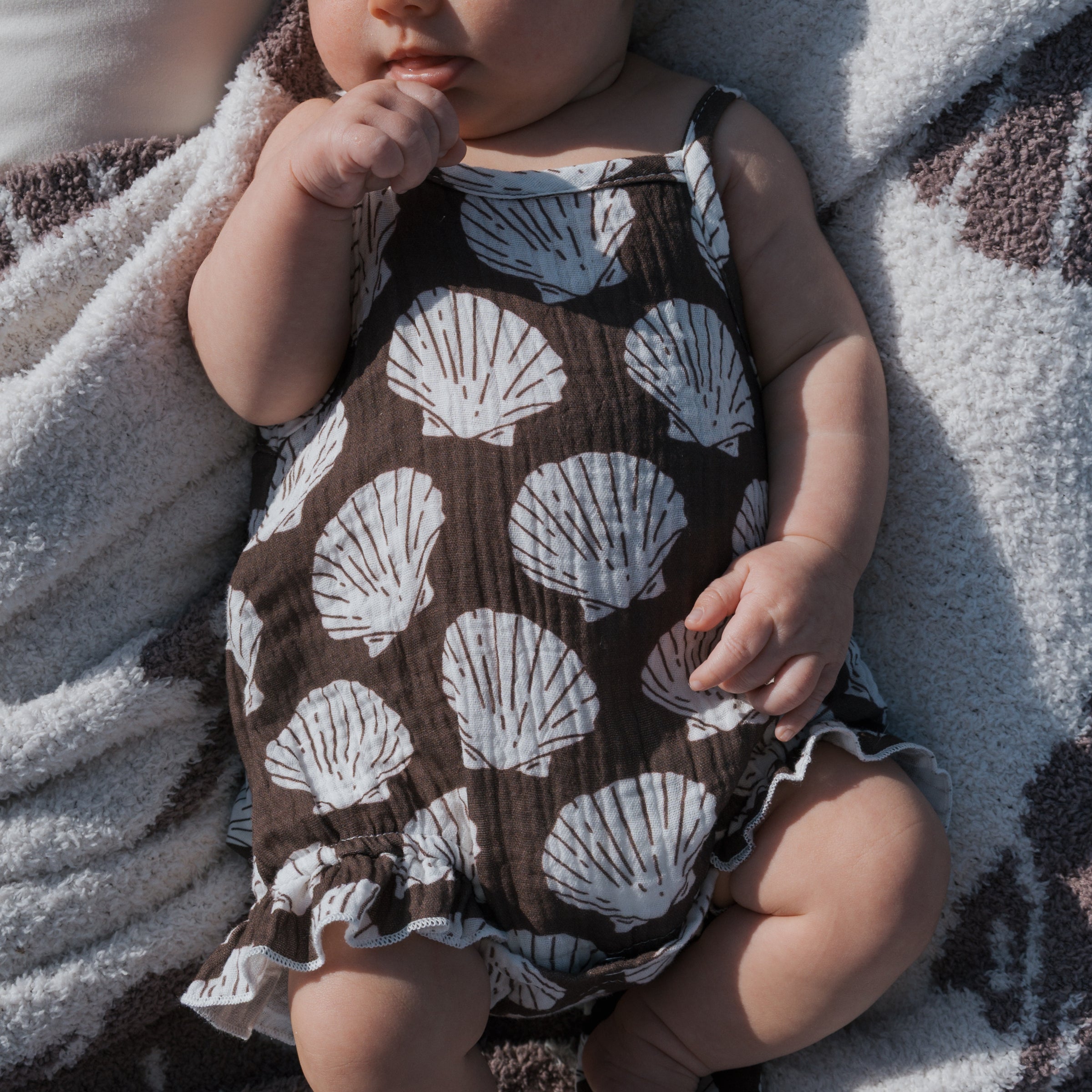 Muslin tank romper featuring a seashell print, perfect for warm days and easy all-day wear.