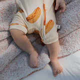 Baby's legs in Hot Dogs | Shortie Bamboo Zip pajamas, relaxing on cozy blanket | milk & baby.