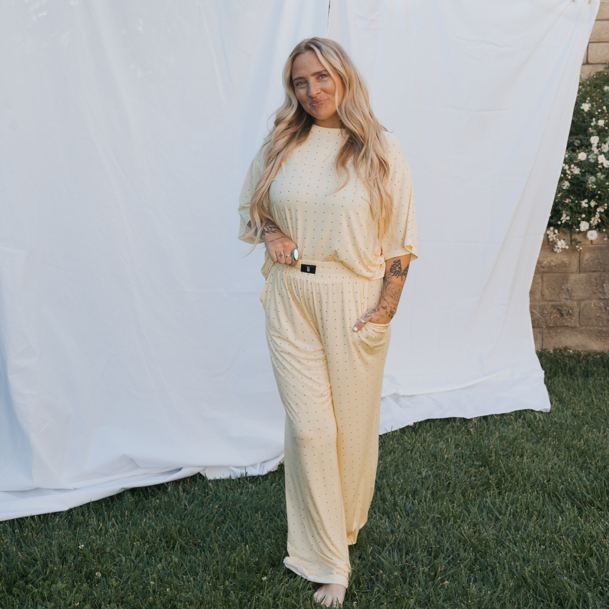 A woman wearing a Women's Boxy Tee Lounge Set in a light yellow color, standing on grass with a relaxed pose.