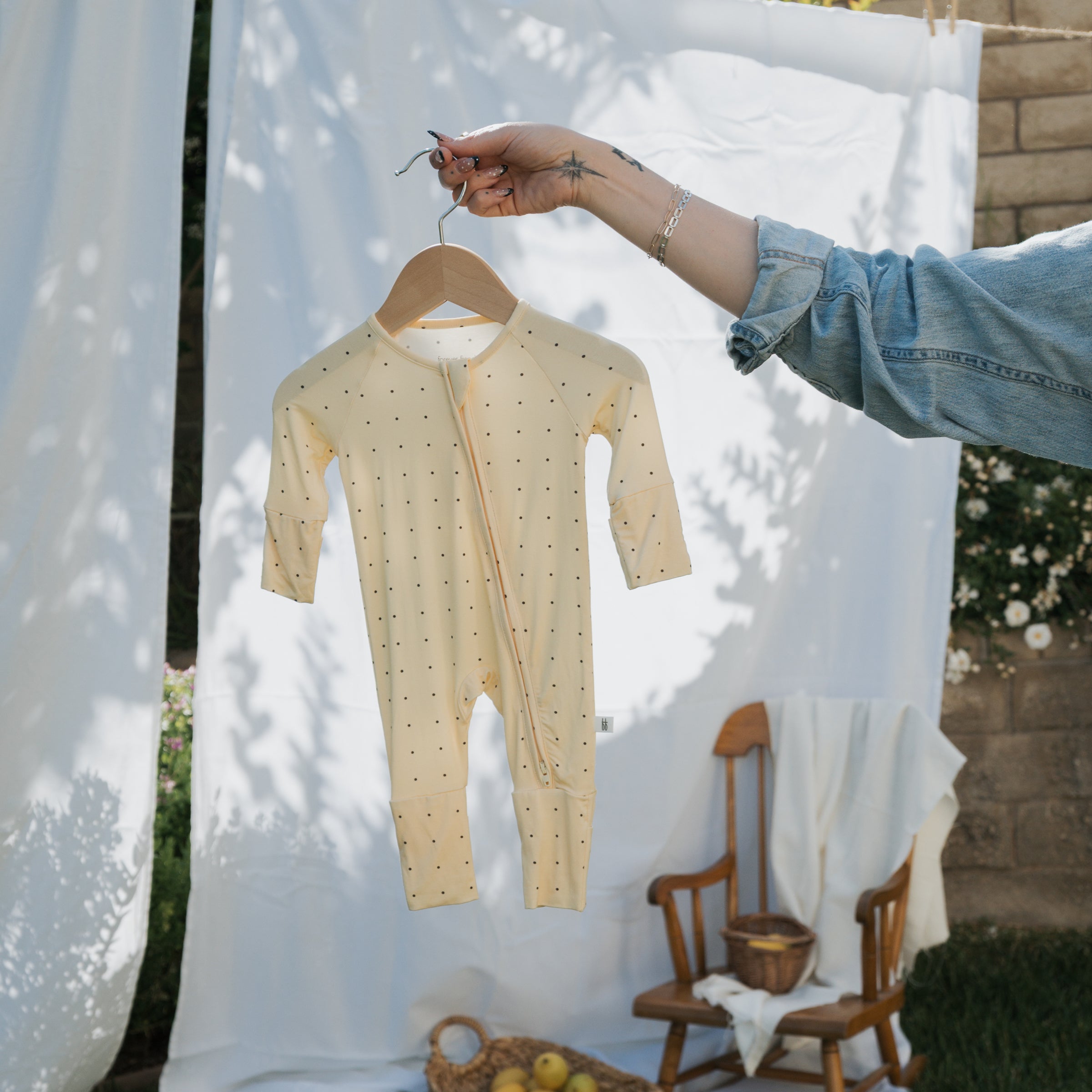 Bamboo Zip Pajamas in yellow hanging on a wooden hanger against a soft background, showcasing the cozy design and durability.