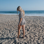 Woman wearing a Women's Bamboo Short Set walking on the beach, showcasing comfort and style in warm weather.