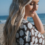 Woman enjoying the beach while wearing the Women's Bamboo Short Set featuring seashell print.