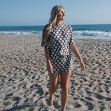Beautiful woman wearing Women's Bamboo Short Set walking on the beach by the ocean, enjoying warm weather and comfort.