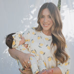 Mom and baby in matching Lemon Bamboo Zip Pajamas, showcasing a cozy, stylish look with vibrant lemon print.